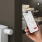 The image shows a ViCare thermostat on a radiator and the ViCare app open on a smartphone